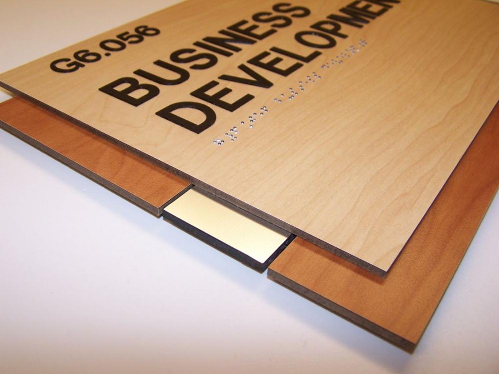 A wall-mounted wooden sign with the text "G6.056 PROFESSIONAL RESOURCES" in black letters. The sign has a light wood finish with two darker wood slats at the top and bottom edges.