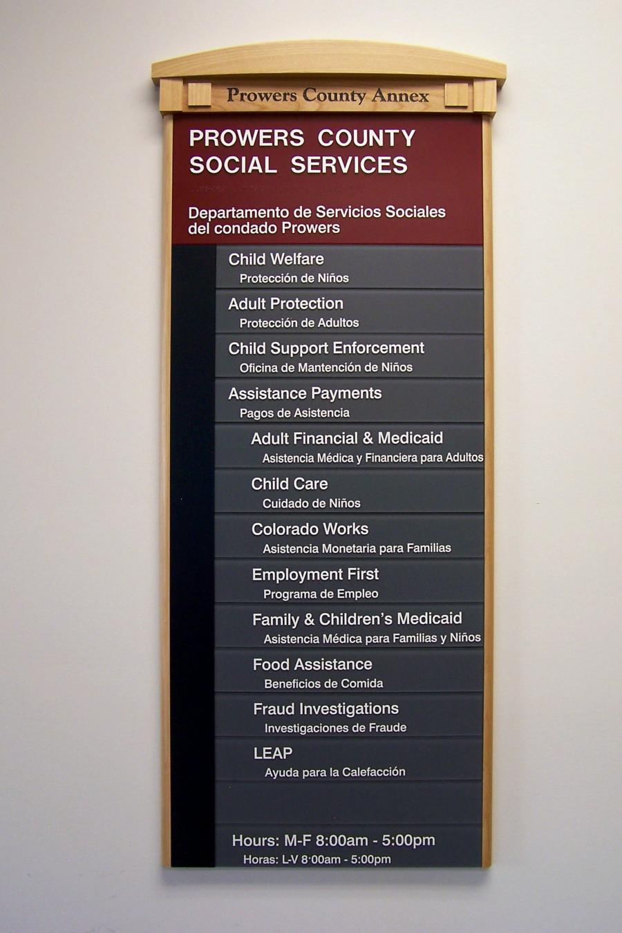 A directory sign for Prowers County Social Services. Services listed include Child Welfare, Adult Protection, Child Support Enforcement, Financial & Medicaid, Child Care, Colorado Works, Employment, Family & Children's Medicaid, Food Assistance, Fraud Investigations, and LEAP. Office hours are M-F 8:00 am - 5:00 pm and LV 8:00 am - 5:00 pm.