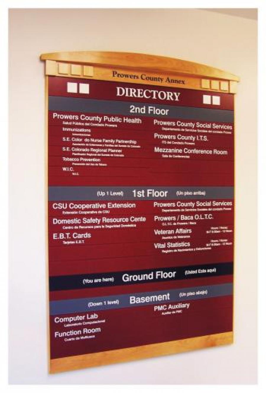 A directory sign for Prowers County Annex displays floor information. The 2nd floor includes Public Health, Social Services, L.T.S., and a conference room. The ground floor lists Cooperative Extension, Resource Center, Veteran Affairs, and Statistics. The basement has a computer lab and function room.