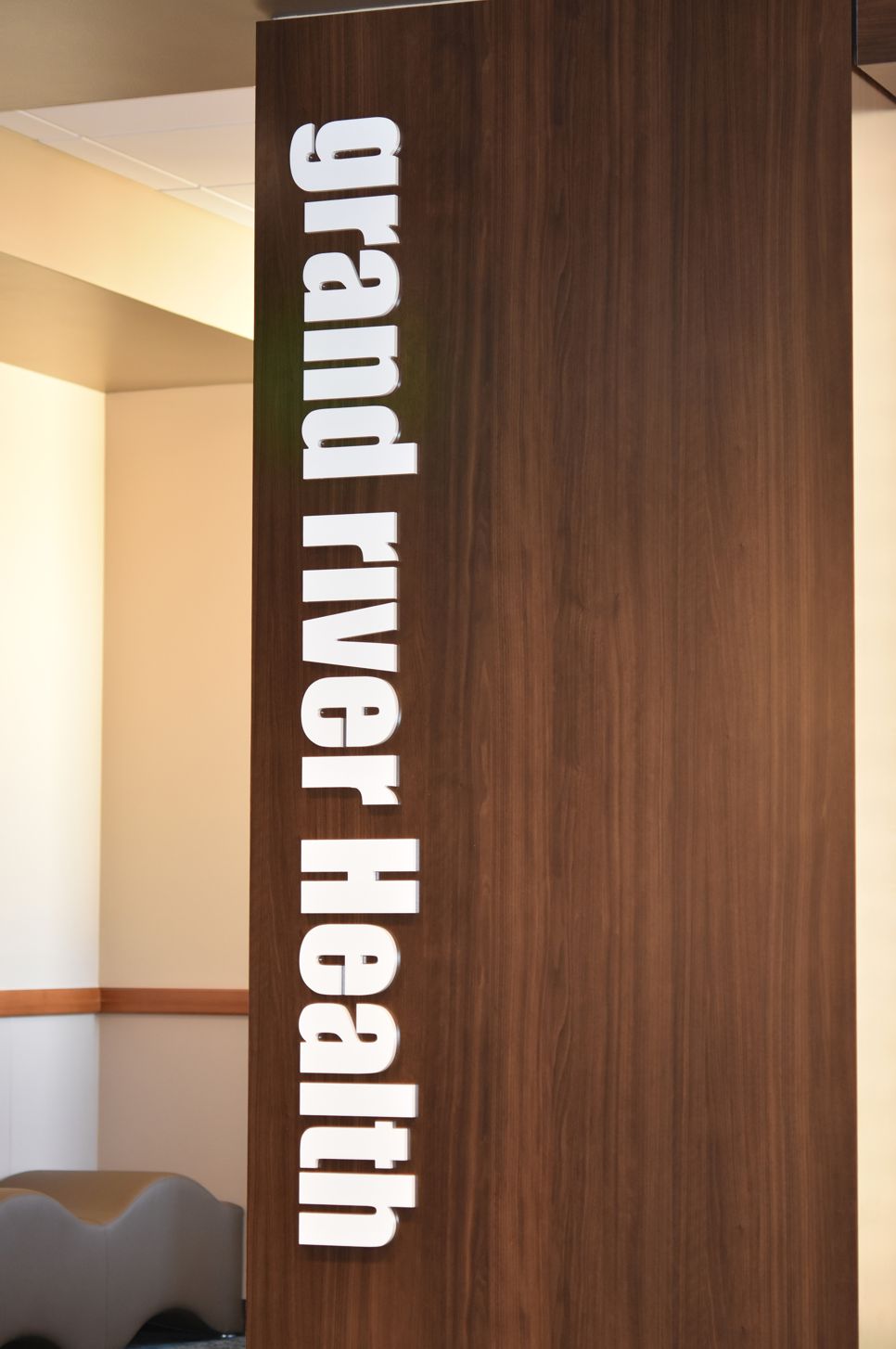 An office featuring a wooden partition with "grand river Health" written vertically in white letters.
