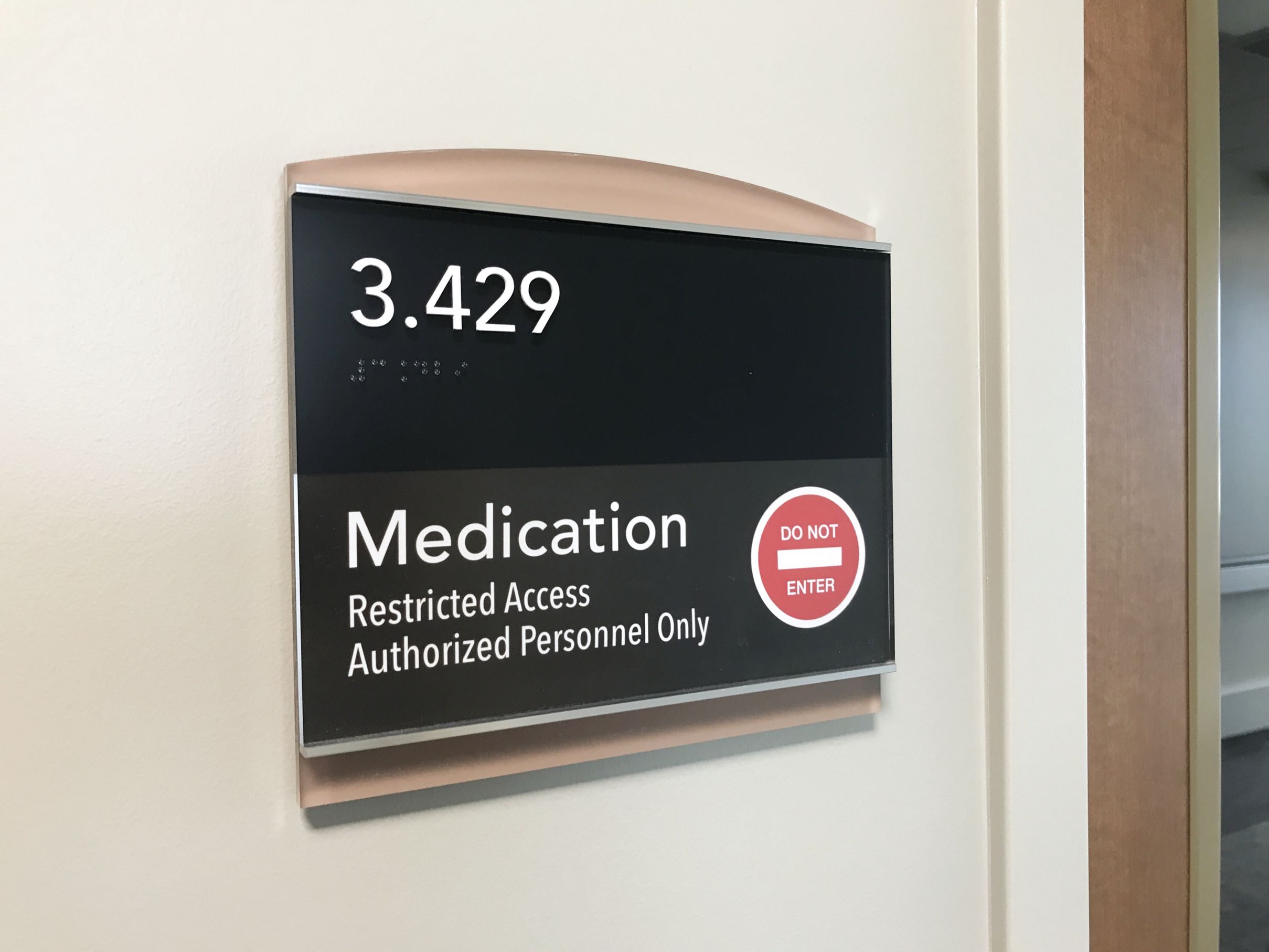 A wall sign indicating a room number 3.429. The sign also reads “Medication,” and “Restricted Access Authorized Personnel Only” with a red circle containing a white line and the words “DO NOT ENTER” in white, signaling restricted access.