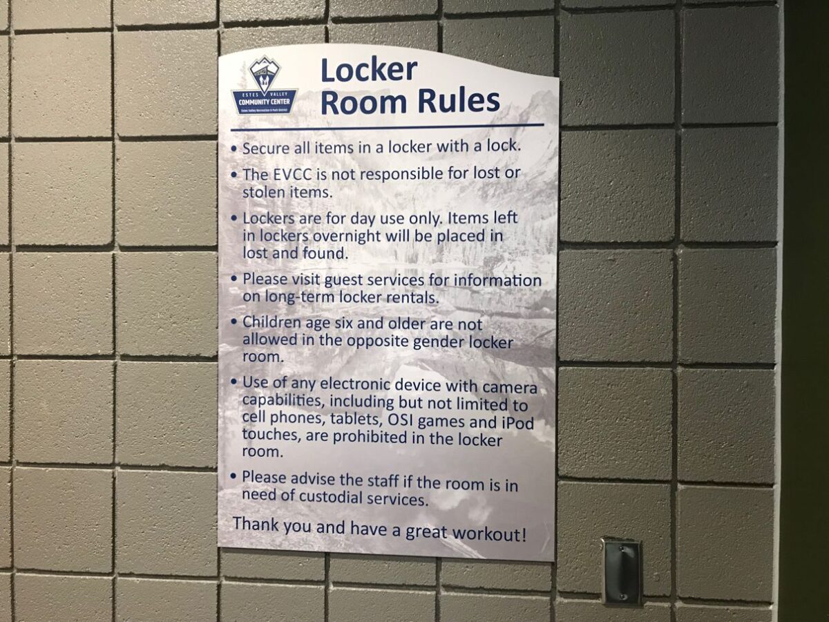 A poster titled "Locker Room Rules" is displayed on a tiled wall. The rules include securing items with a lock, the facility not being responsible for lost or stolen items, and guidelines for daily locker use, guest services, and electronic devices.