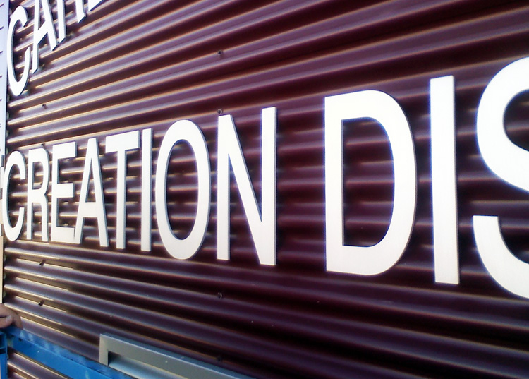 The image shows the exterior wall of a building with the words "Carbon Valley Recreation District" displayed in large, white letters. The wall is brown with vertical panels, and this is a close-up of the lettering.