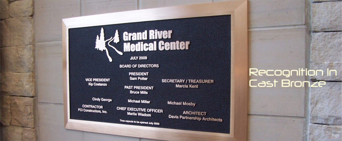 A cast bronze plaque mounted on a wall, titled "Grand River Medical Center." It lists the Board of Directors, President, Vice President, Treasurer, and other roles, along with names under each title. The text indicates the plaque is made by Recognition in Cast Bronze.