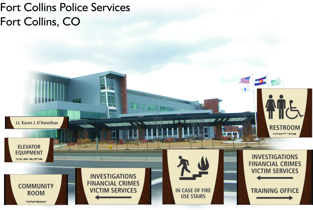 Photo of Fort Collins Police Services building in Fort Collins, CO. In the foreground, there are signs in English and Braille indicating locations for restrooms, elevator equipment, community rooms, and offices for investigations, financial crimes, and training.