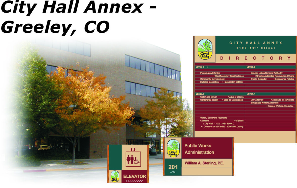 "Image of the City Hall Annex in Greeley, CO, with a directory sign showing various departments and their locations. An elevator sign and the Public Works Administration office details are also displayed. A building with autumn trees is seen in the background.