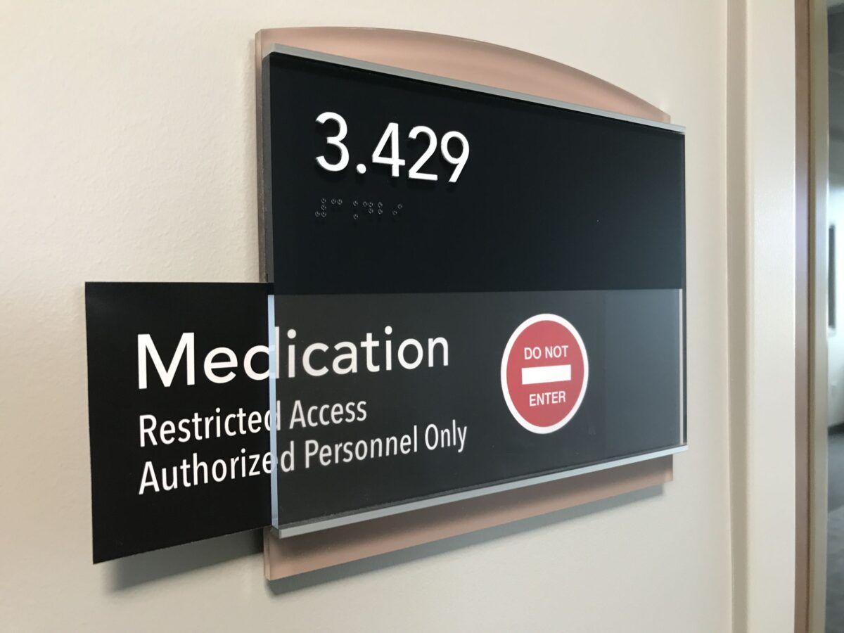 A wall sign indicating a room number 3.429. The sign also reads “Medication,” and “Restricted Access Authorized Personnel Only” with a red circle containing a white line and the words “DO NOT ENTER” in white, signaling restricted access.