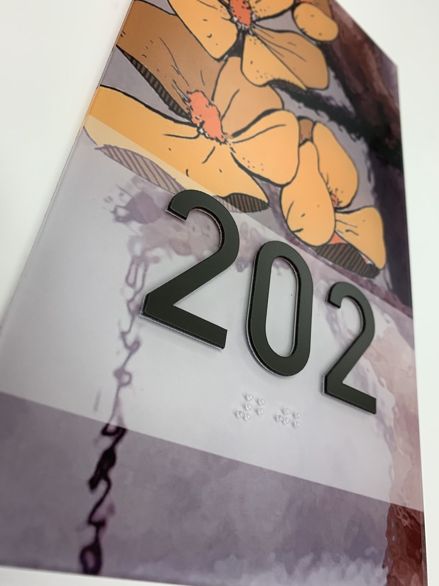 A close-up of a door number sign featuring large black numbers "202" in bold. The background has artistic, abstract designs with shades of gray and purple on the left and yellow flowers on the right.