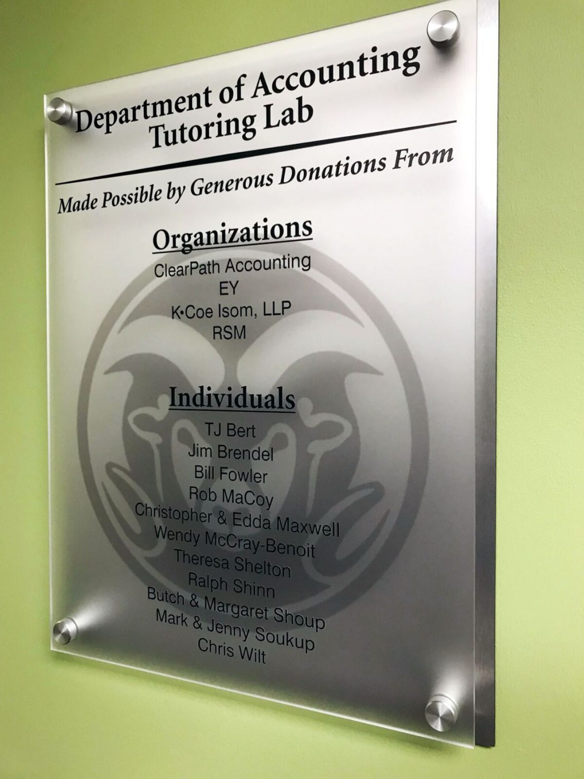 A frosted glass sign in the Department of Accounting Tutoring Lab lists generous donations from various organizations and individuals. The sign includes names like ClearPath Accounting, EY, and several individuals. The background features a subtle university logo.
