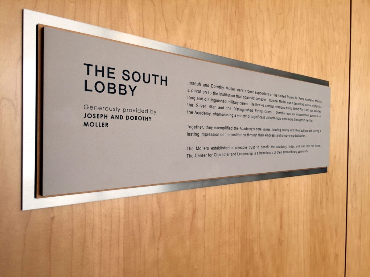 A metal plaque mounted on a wooden surface reads: "The South Lobby. Generously provided by Joseph and Dorothy Moller." It includes a paragraph of text describing the lobby's features and its purpose.