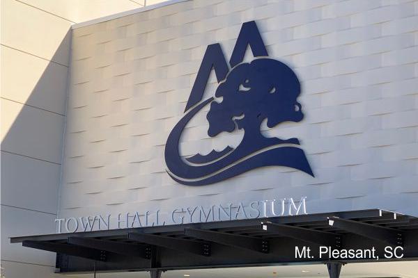 Exterior of the Town Hall Gymnasium in Mt. Pleasant, SC, showcasing a large stylized logo mounted on a white modern building facade.