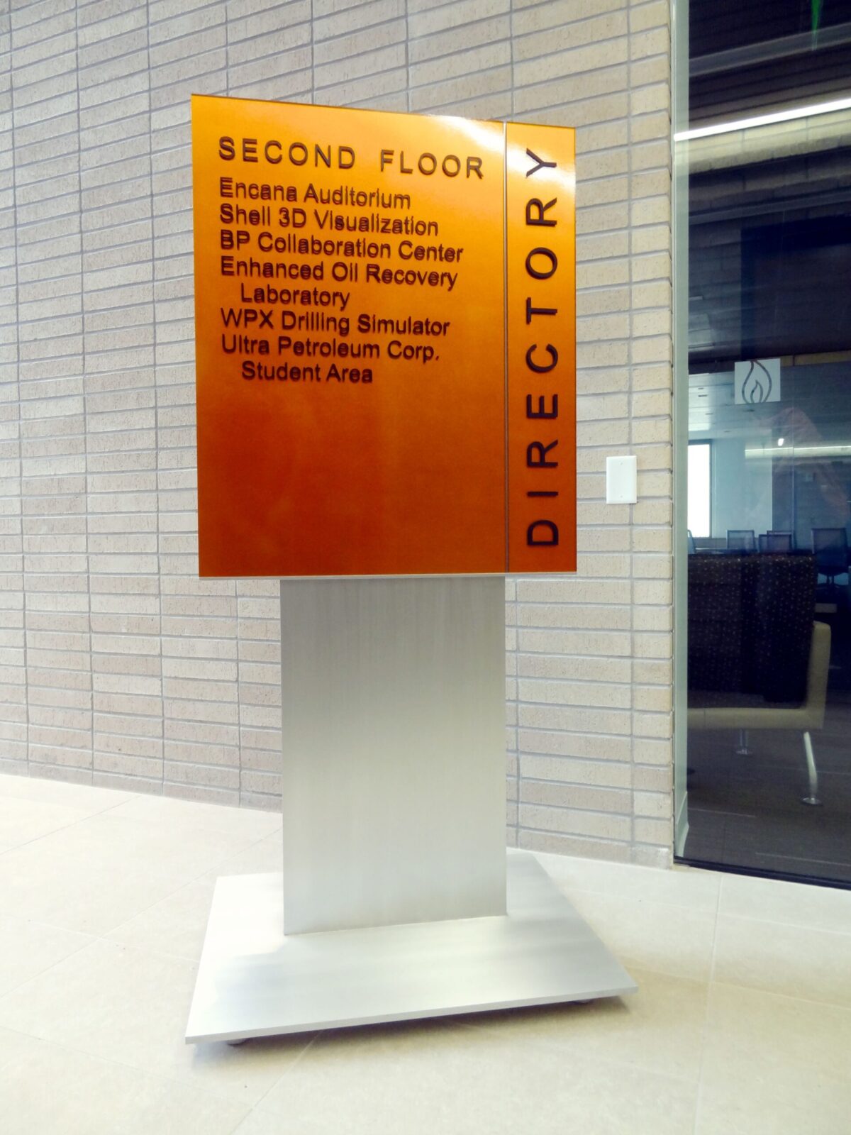 An upright directory sign with "SECOND FLOOR" at the top, listing locations: Encana Auditorium, Shell 3D Visualization, BP Collaboration Center, Enhanced Oil Recovery Laboratory, WPX Drilling Simulator, Ultra Petroleum Corp., and Student Area.