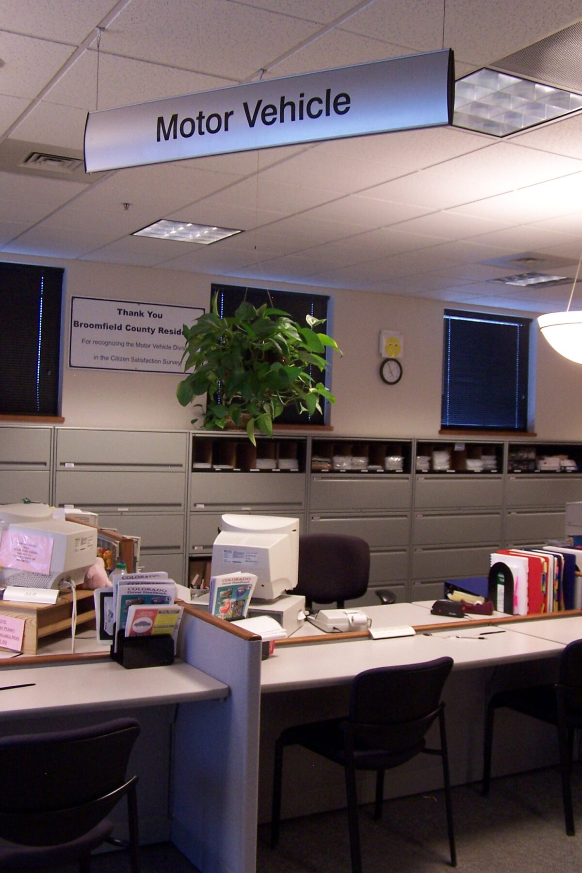 An office space with a sign reading "Motor Vehicle" hanging from the ceiling.