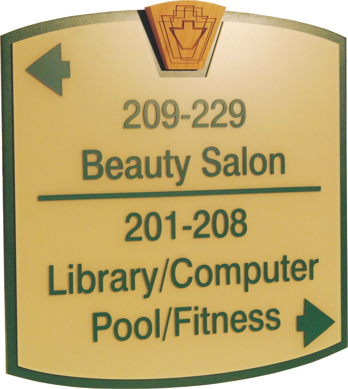 A directional sign with a yellow background and green edges. The sign indicates room numbers and locations: "209-229 Beauty Salon" with an arrow pointing left, and "201-208 Library/Computer Pool/Fitness" with an arrow pointing right.