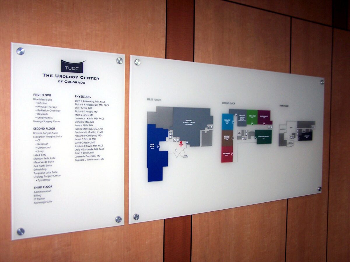 A wall-mounted directory and map at The Spencer Center of Delaware. The left panel lists services and locations, while the right panel shows a color-coded floor plan with labeled rooms. The background wall is wooden.