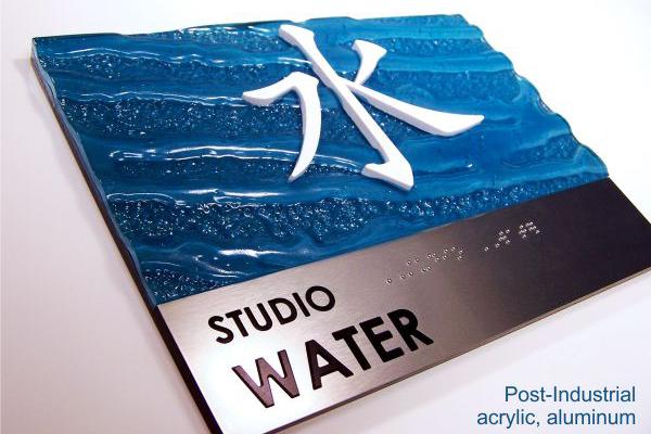 Artistic studio sign 'Studio Water' with a blue textured background representing water waves, complemented by white and silver elements.