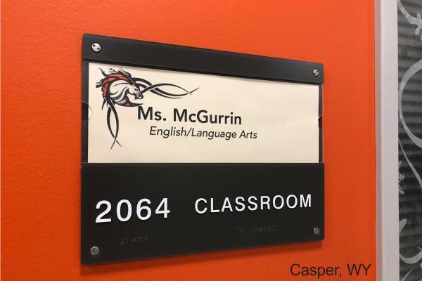 Classroom door sign for Ms. McGurrin, English/Language Arts, in Casper, WY, featuring a red and black design with a graphic of a stylized dragon.