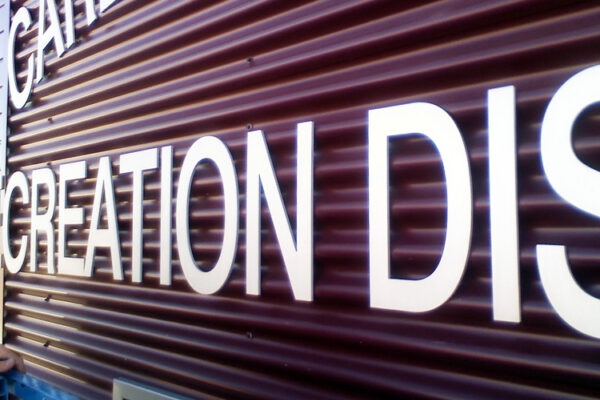 The image shows the exterior wall of a building with the words "Carbon Valley Recreation District" displayed in large, white letters. The wall is brown with vertical panels, and this is a close-up of the lettering.