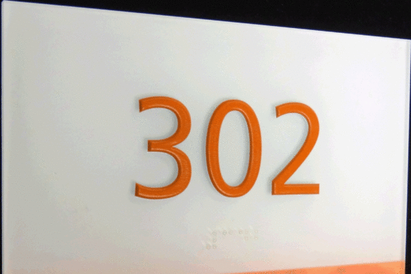 A sign reads "302" in large orange numbers on a white background. Below the numbers, there is a marbled orange strip with "Clemson University" written in white uppercase letters.