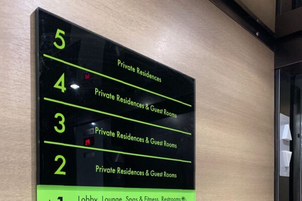 A black and green directory sign in a building. The levels listed are: 5 - private residences; 4 - private residences and guest rooms; 3 - private residences and guest rooms; 2 - private residences and guest rooms; 1 - lobby, lounge, spa & fitness, restaurant, climbing wall, ski storage, guest suites; LV - conference rooms, great rooms; P1, P2, P3 - public parking.