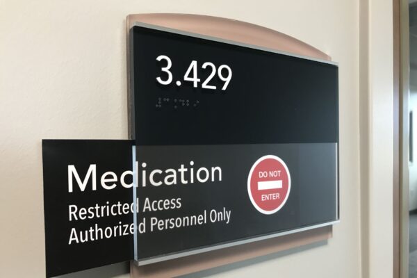 A wall sign indicating a room number 3.429. The sign also reads “Medication,” and “Restricted Access Authorized Personnel Only” with a red circle containing a white line and the words “DO NOT ENTER” in white, signaling restricted access.