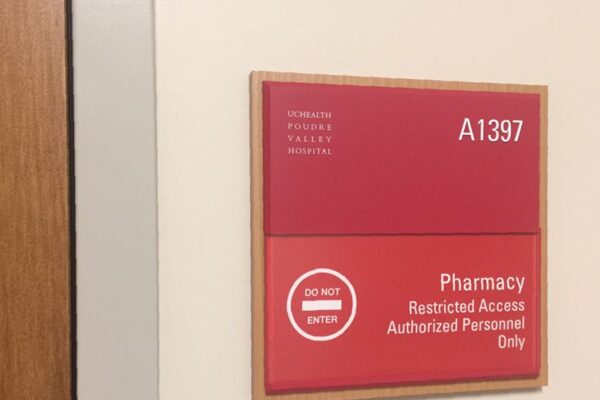 A red sign on a wall reads, "Pharmacy A1397" and "Restricted Access Authorized Personnel Only" with a "DO NOT ENTER" symbol.