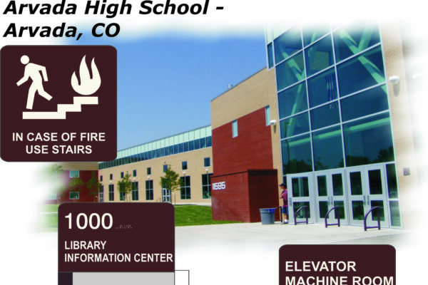 An image of Arvada High School in Colorado shows a modern building with large windows and an outdoor staircase. Signs include: "In case of fire use stairs," "1000 - Social Studies, Library Information Center," and "Elevator Machine Room.