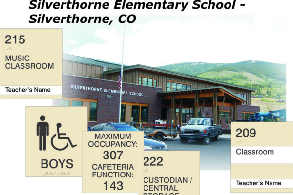 A building with a sign that reads "Silverthorne Elementary School." Various informational signs are overlaid, indicating room numbers and their uses: 215 (Music Classroom), 209 (Classroom), Custodian/Central Storage, a restroom sign for boys, and occupancy details.