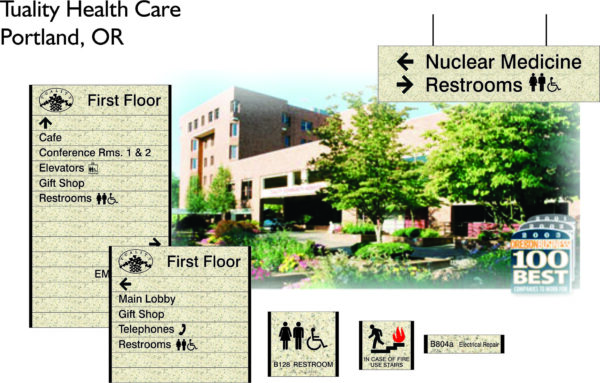 Image showing directories and signage for Tuality Health Care in Portland, OR. The signs list facilities on the first floor and direct to nuclear medicine, restrooms, and emergency exits. The background features the exterior of the health care building with landscaping.