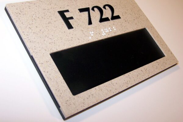 A gray rectangular sign with black text displaying "F 722" positioned on a white background. Below the text is a black empty rectangular space, possibly for customizable text or additional information. The sign appears to be mounted on a wall.