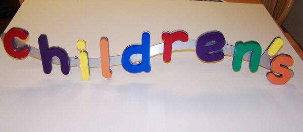 Colorful wooden letters spelling "children's" are arranged in a playful, slightly uneven line on a white background. Each letter is uniquely colored, adding a vibrant, cheerful feel to the composition.