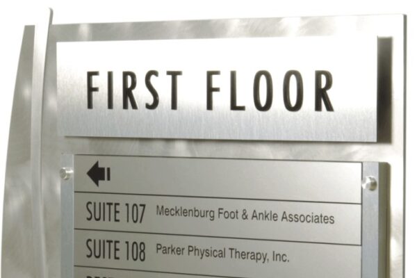 A first floor directory on the right provides a list of locations specifically for the first floor including directional arrows and icons for Restrooms.