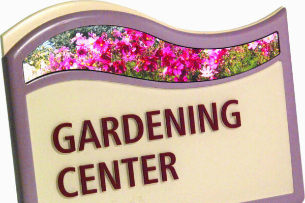 A sign with a wavy top border features the words "GARDENING CENTER" in bold red letters on a cream background. The top section of the sign contains an image of vibrant pink flowers. The border of the sign is a muted purple color.