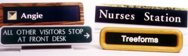 The image shows four different signs. The top left sign reads "Angie." The top right sign reads "Nurses Station." The bottom left sign reads "ALL OTHER VISITORS STOP AT FRONT DESK." The bottom right sign reads "Treeforms".